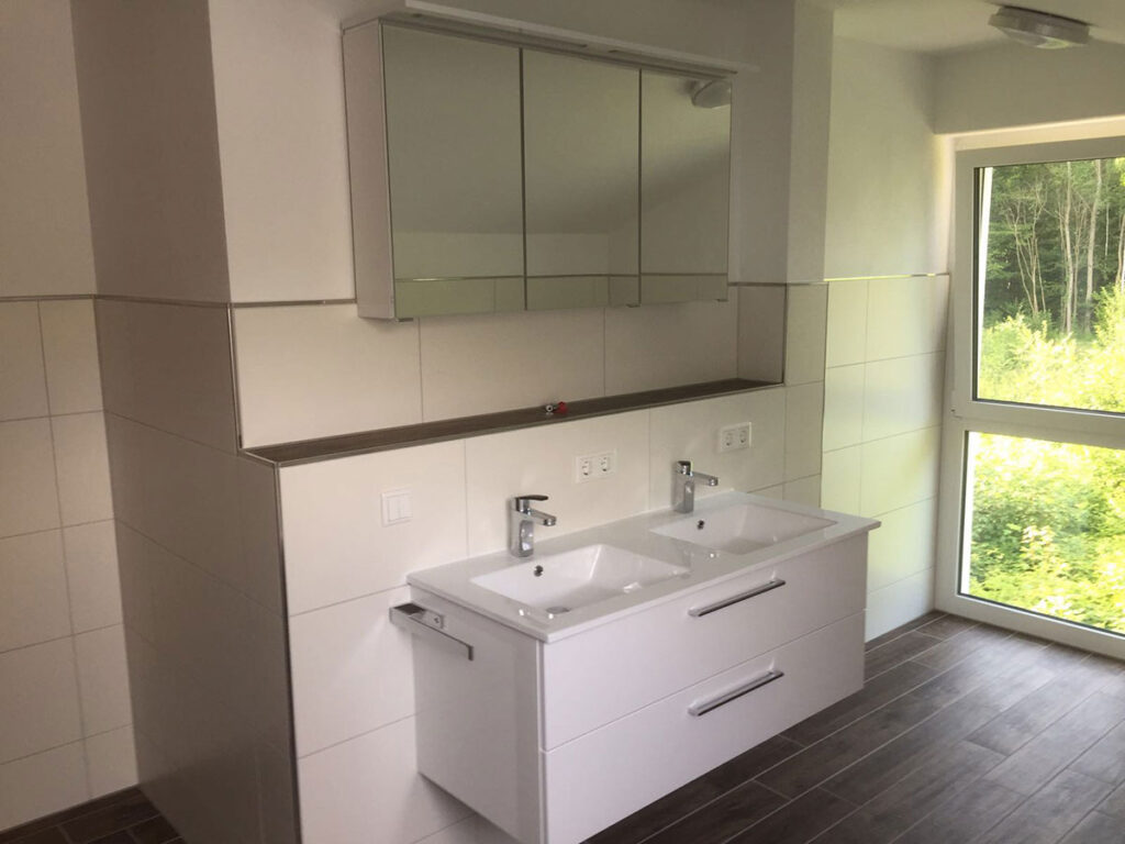 Newly built bathroom with double sink and mirror cabinet